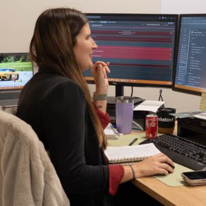 Woman working at desktop computer with two monitors